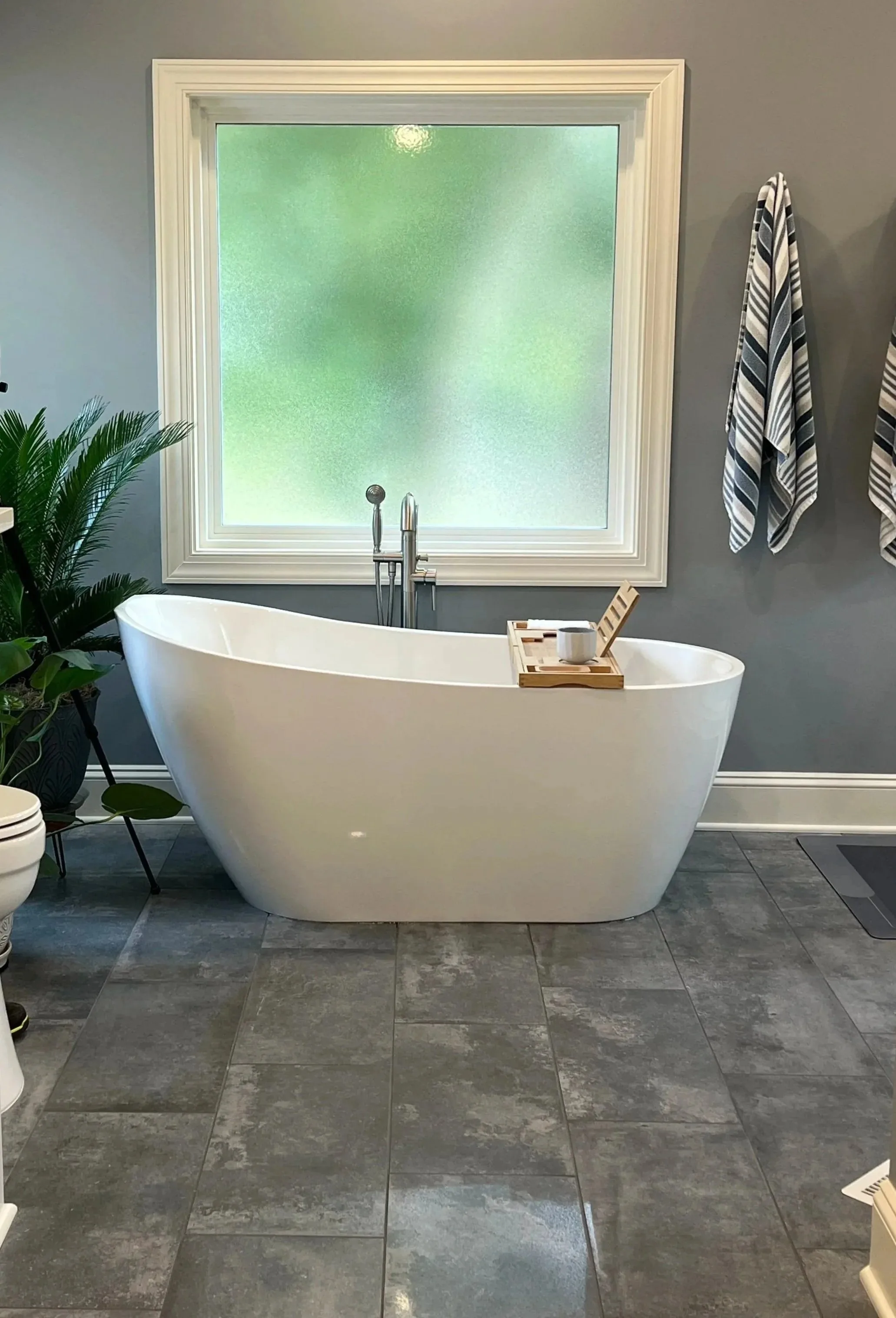 Remodeled bathroom with a white freestanding soaking tub