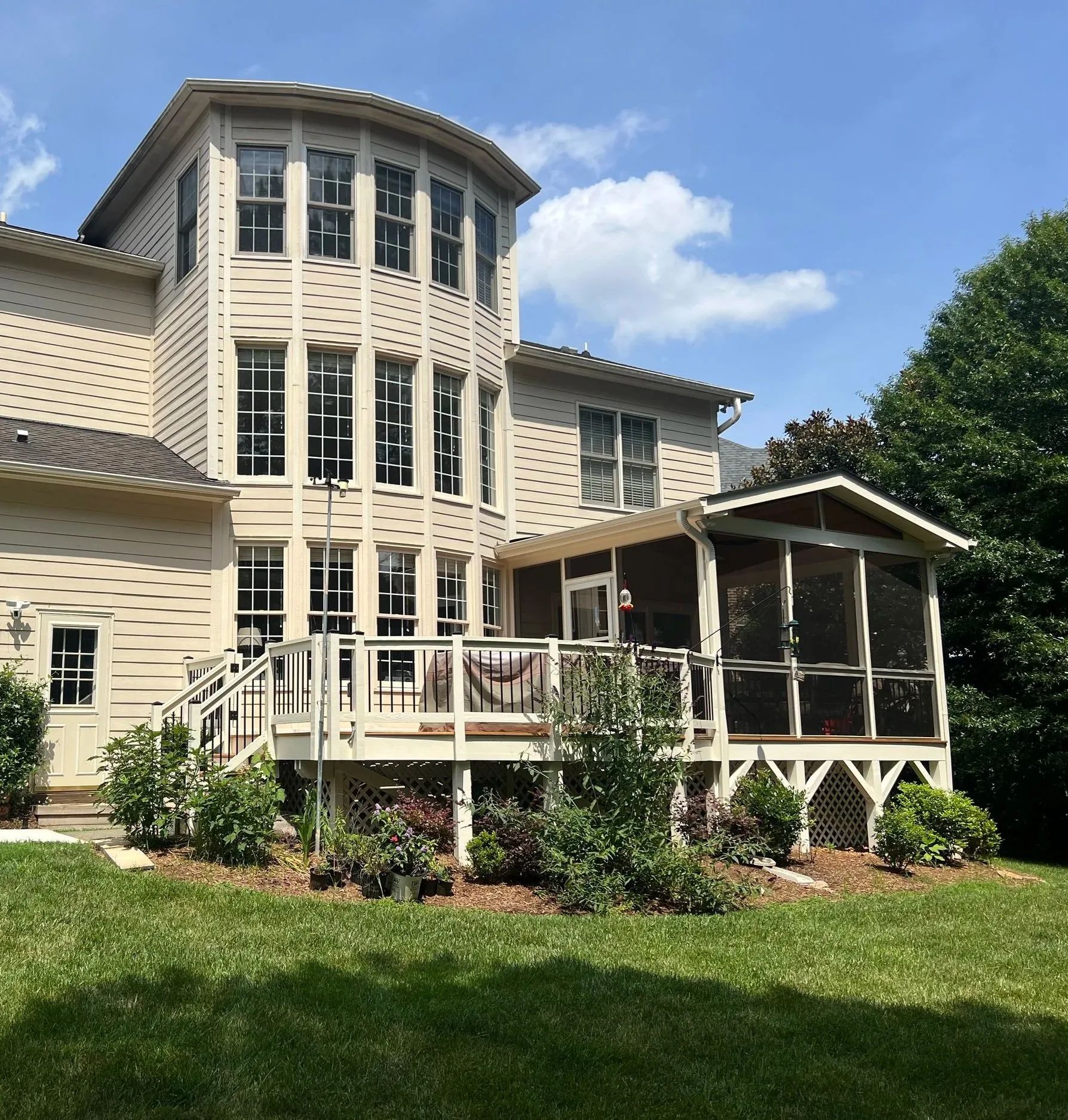 Raised backyard deck with an attached screened porch built by Bright Ridge Construction
